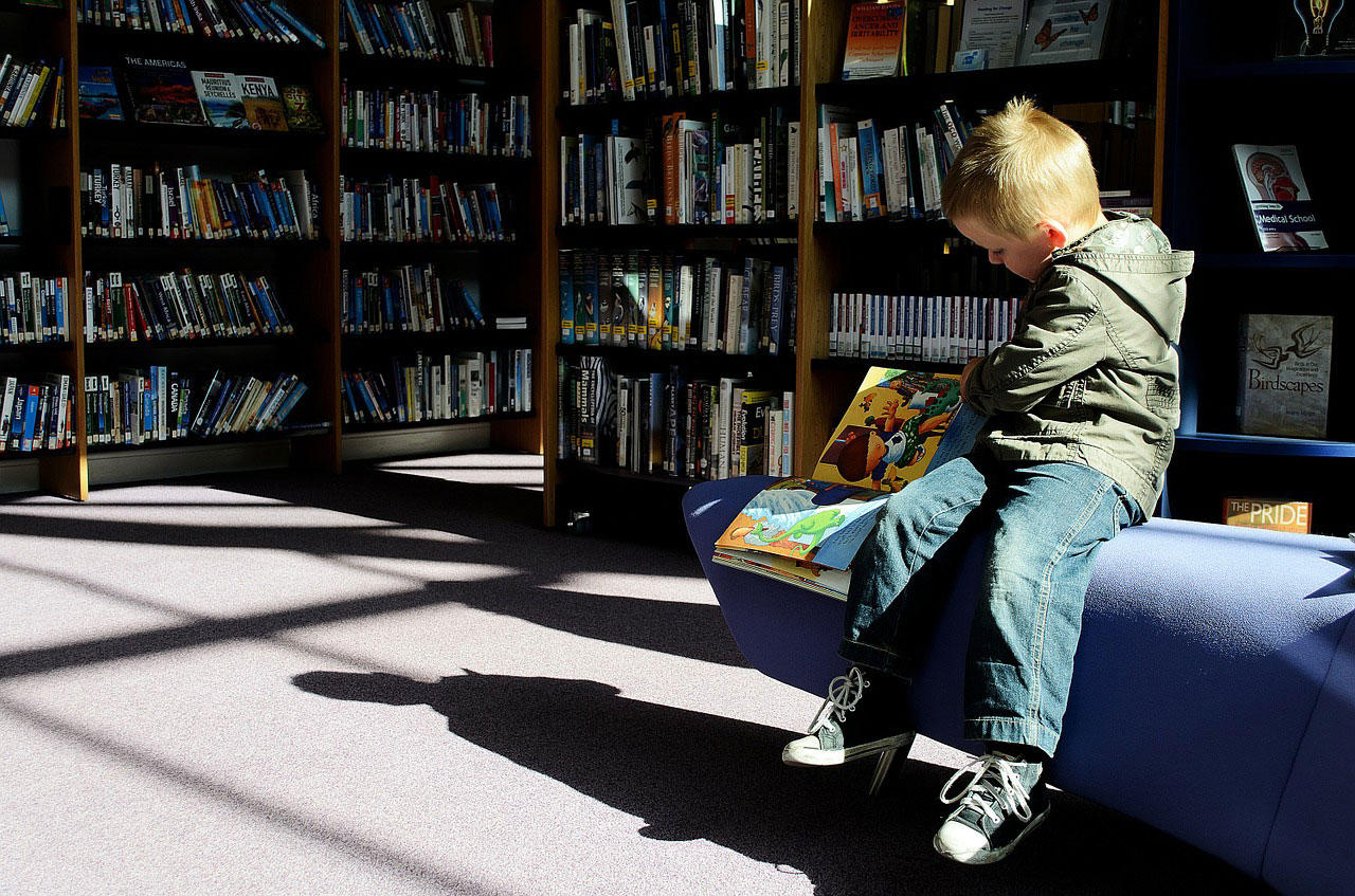enfant dans une bibliothA¨que Photo enfant dans une bibliothA¨que